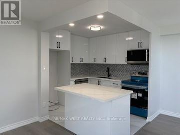 Mississauga (Cooksville) condo for rent - A kitchen with white cabinets and a white island.