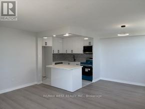 Mississauga (Cooksville) condo for rent - A kitchen with white cabinets and a white island in the middle.