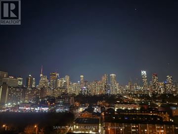 Toronto (Regent Park) condo for rent - A city skyline at night with buildings lit up and a dark sky.
