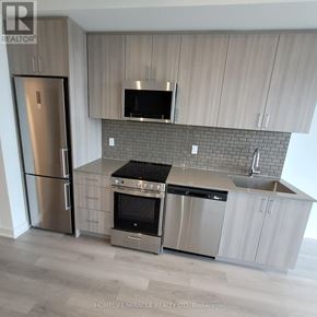 Oakville (Jm Joshua Meadows) condo for rent - A modern kitchen with a stainless steel refrigerator and oven.