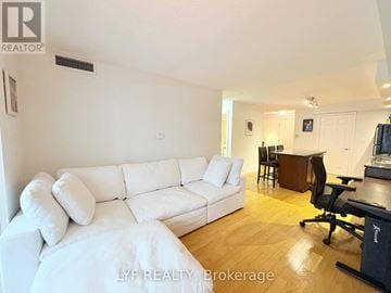 Toronto (Waterfront Communities) condo for rent - A white couch sits in a living room with a desk and chair in the background.
