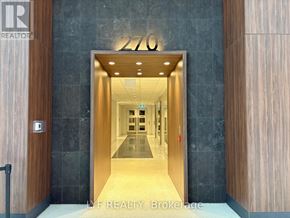Toronto (Waterfront Communities) condo for rent - The image shows a modern entrance to a building with a glass door and a sign that reads "276".