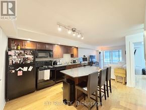 Toronto (Waterfront Communities) condo for rent - A kitchen with a black fridge and black appliances.