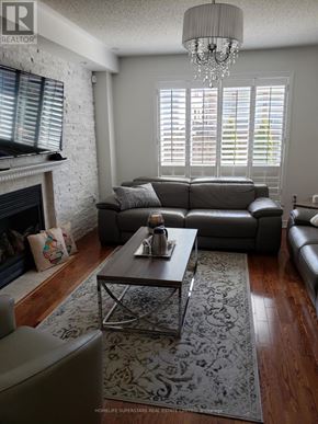 Mississauga (Churchill Meadows) apartment for rent - A living room with a grey couch, a coffee table, and a fireplace.
