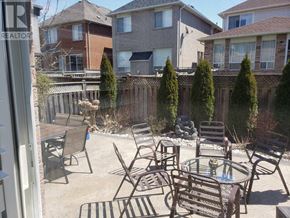 Mississauga (Churchill Meadows) apartment for rent - A patio with a table and chairs surrounded by a fence.
