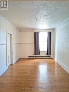 Burlington (Brant) apartment for rent - A room with wooden floors and a window with curtains.