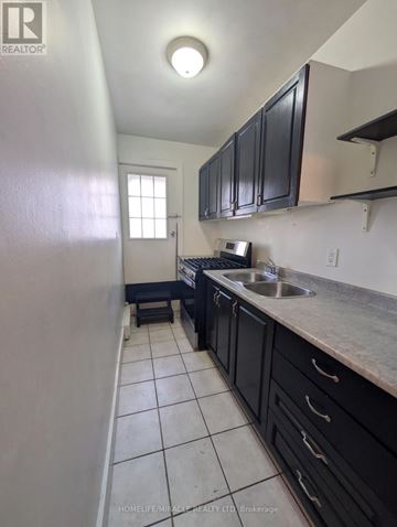 Burlington (Brant) apartment for rent - A kitchen with black cabinets and a white refrigerator.