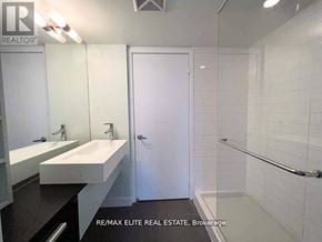 Toronto (Waterfront Communities) condo for rent - A white sink with a mirror above it and a white door to the right.