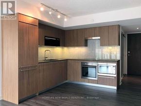 Toronto (Waterfront Communities) condo for rent - A modern kitchen with wooden cabinets and stainless steel appliances.