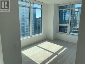 Toronto (Waterfront Communities) condo for rent - A room with a large window overlooking a cityscape.