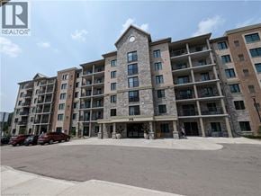 Waterloo condo for rent - A large apartment building with a parking lot in front.