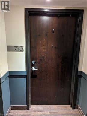 Waterloo condo for rent - A brown door with a silver handle and a number 710 on the wall above it.