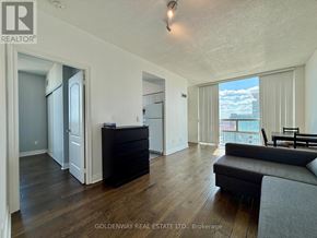 Toronto (Bendale) condo for rent - A living room with a couch, a chair, and a large window overlooking the city.