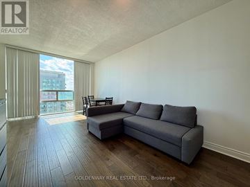 Toronto (Bendale) condo for rent - A living room with a grey sofa and a wooden floor.
