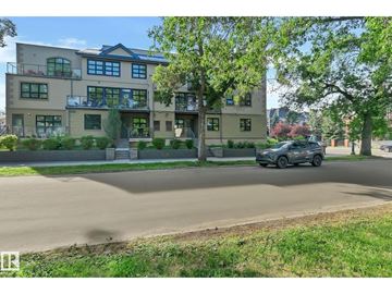 Edmonton apartment for rent - A car is driving down a tree-lined street past a large apartment building.