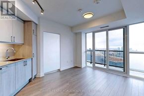 Toronto (Church-Yonge Corridor) condo for rent - A spacious room with wooden floors and a large window overlooking a construction site.