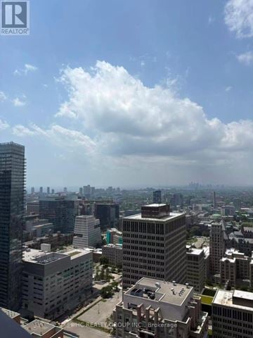 Toronto (Bay Street Corridor) condo for rent - A cityscape with a mix of residential and commercial buildings under a partly cloudy sky.