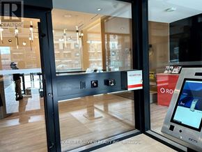 Vaughan (Beverley Glen) condo for rent - A modern office lobby with a glass door and a safety sign on the wall.