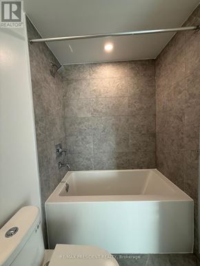 Toronto (Church-Yonge Corridor) condo for rent - A white bathtub in a bathroom with beige tiles.