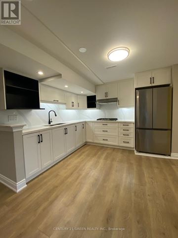 Oakville (Br Bronte) apartment for rent - A kitchen with white cabinets and a wooden floor.
