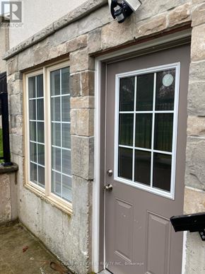 Oakville (Br Bronte) apartment for rent - A grey door with a window to the left of it.