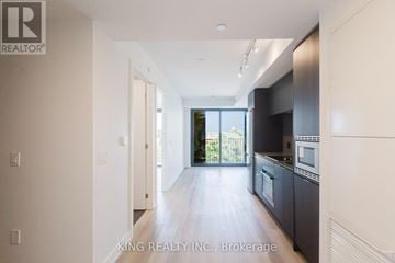 Hamilton (Beasley) condo for rent - A spacious kitchen with dark cabinets and a large window.