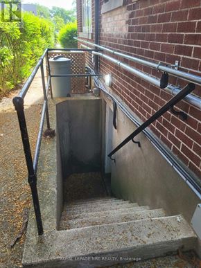 St. Catharines (Old Glenridge) apartment for rent - A stairway with a metal handrail goes down to a concrete basement.