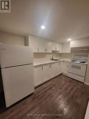 St. Catharines (Old Glenridge) apartment for rent - A kitchen with white appliances and wooden floors.