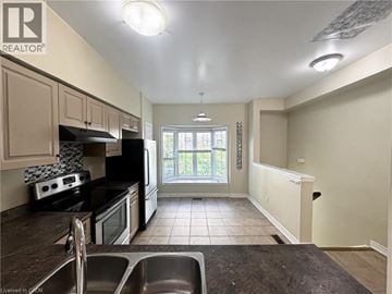 Burlington townhouse for rent - A kitchen with black appliances and white walls.