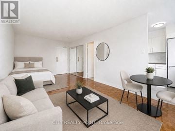 Toronto (Church-Yonge Corridor) condo for rent - A well-lit, modern bedroom with a large bed, a couch, a coffee table, and a dining area with a table and chairs.