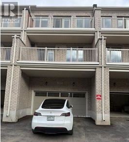 Oakville (Go Glenorchy) townhouse for rent - A white car is parked in a garage of a multi-story building.