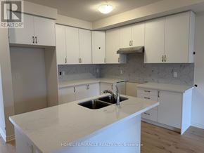 Oakville (Go Glenorchy) townhouse for rent - A kitchen with white cabinets and a marble countertop.
