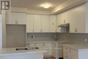 Oakville (Go Glenorchy) townhouse for rent - A kitchen with white cabinets and a countertop.