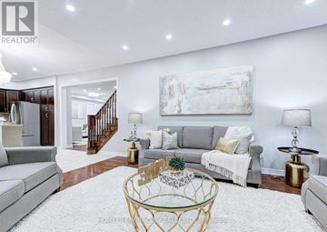 Brampton (Bram West) apartment for rent - A living room with a grey couch, a glass coffee table, and a painting on the wall.