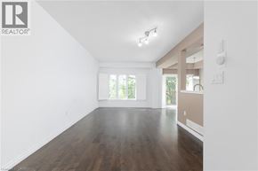 Ancaster townhouse for rent - A spacious room with wooden floors and white walls.
