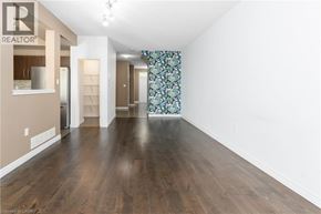 Ancaster townhouse for rent - A spacious room with wooden floors and a large window with a floral curtain.