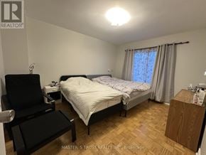 Toronto (Bayview Woods-Steeles) townhouse for rent - A bedroom with a bed, chair, and window.