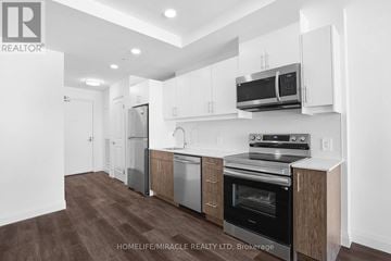 Kitchener condo for rent - A modern kitchen with wooden floors and white walls.