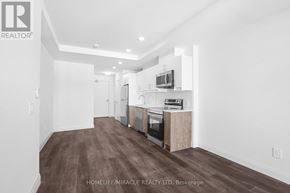 Kitchener condo for rent - A spacious kitchen with wood flooring and white walls.