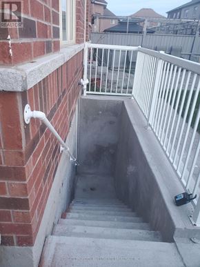 Whitchurch-Stouffville (Stouffville) apartment for rent - A staircase with a white railing and a brick wall.