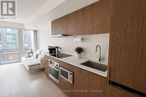 Toronto (Church-Yonge Corridor) condo for rent - A modern kitchen with wooden cabinets and a white countertop.