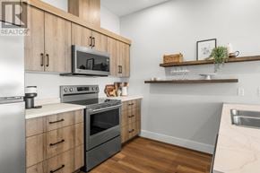 Charlottetown condo for rent - A kitchen with wooden cabinets and a microwave above the stove.