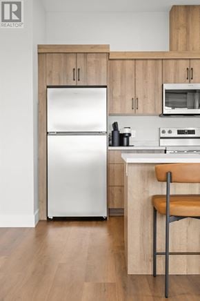 Charlottetown condo for rent - A modern kitchen with a refrigerator, oven, and microwave.