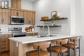 Charlottetown condo for rent - A modern kitchen with a white countertop and brown chairs.