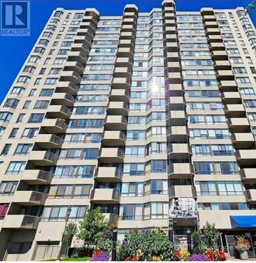 Toronto (Steeles) condo for rent - A tall residential building with balconies and a blue awning in front.