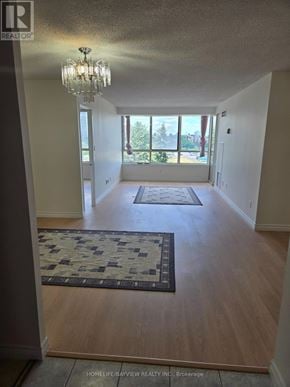 Toronto (Steeles) condo for rent - A hallway with a rug and a chandelier.