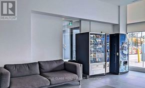 Oshawa (Samac) condo for rent - A grey sofa sits in a room with a vending machine.