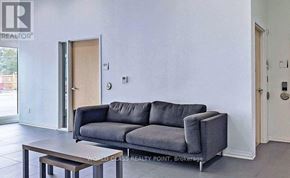 Oshawa (Samac) condo for rent - A grey couch sits in a room with a wooden coffee table.