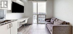 Oshawa (Samac) condo for rent - A living room with a grey couch and a television.