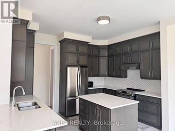 Oakville (Go Glenorchy) apartment for rent - A modern kitchen with dark cabinets and stainless steel appliances.